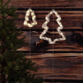 Brad de Crăciun iluminat și acoperit de zăpadă